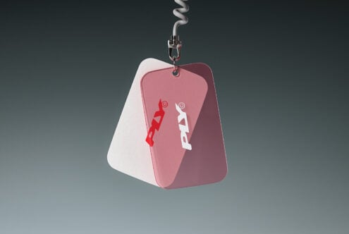 Dog tag keychain mockup with rounded edges, red white color palette, hanging from coiled metal cable against neutral background