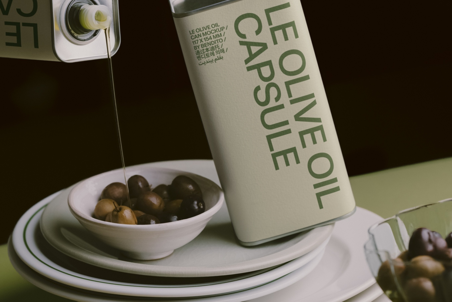 Olive oil can mockup with pouring shot, olives in bowl, multilingual packaging