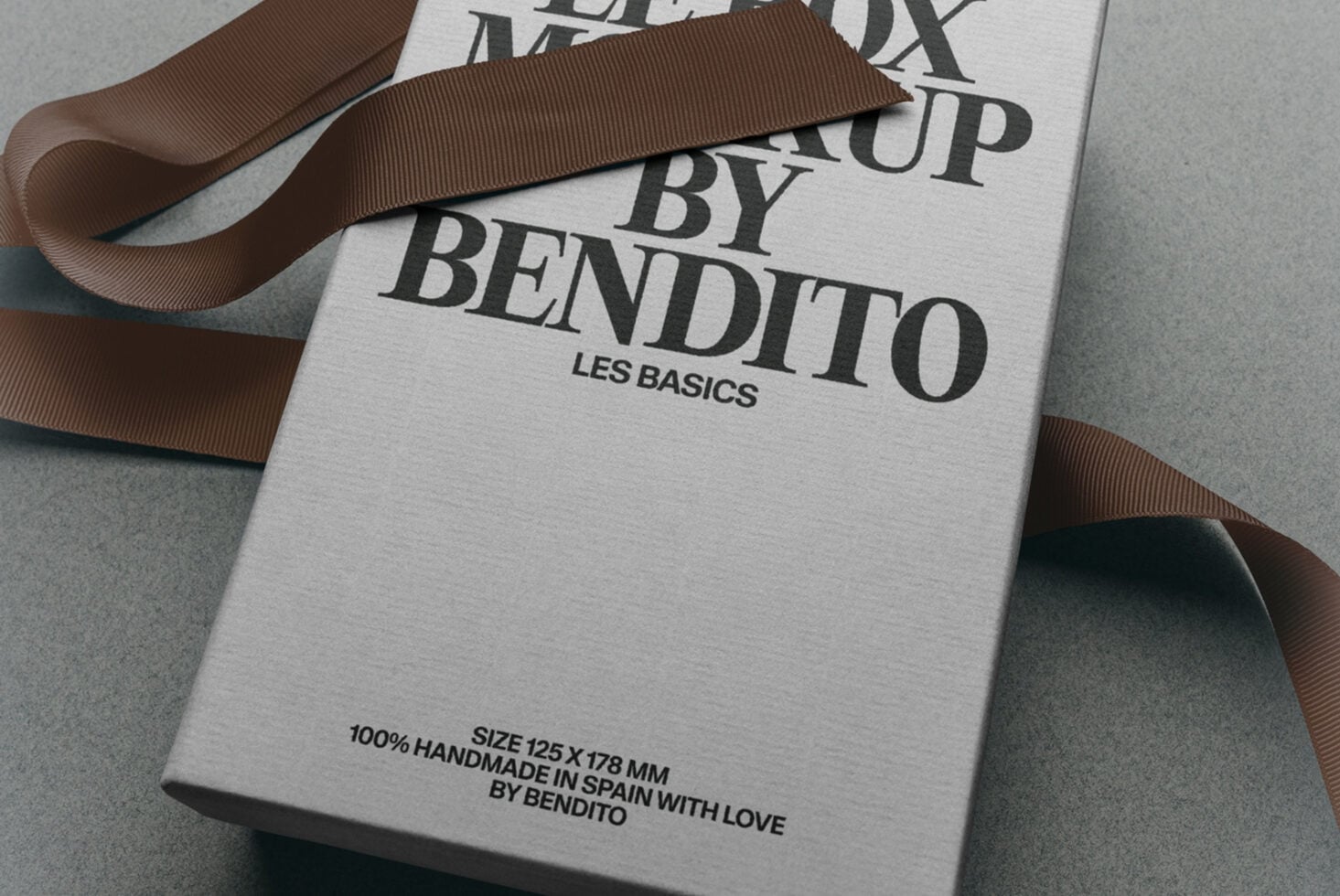 Luxury box packaging mockup with brown grosgrain ribbon, serif typography, Les Basics branding, handmade in Spain details visible