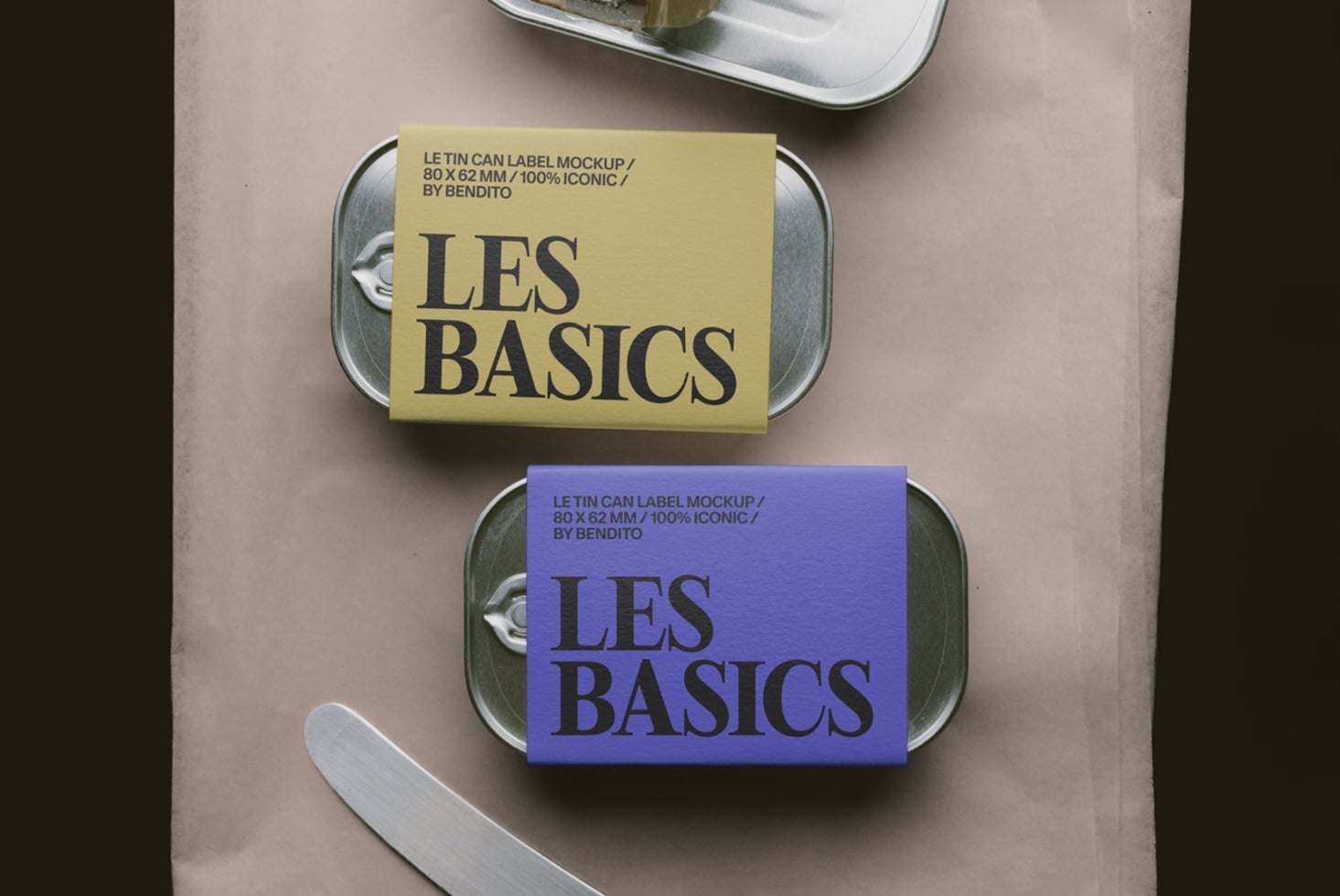 Two tin can labels in yellow plus blue sitting on glass containers, overhead flat lay shot