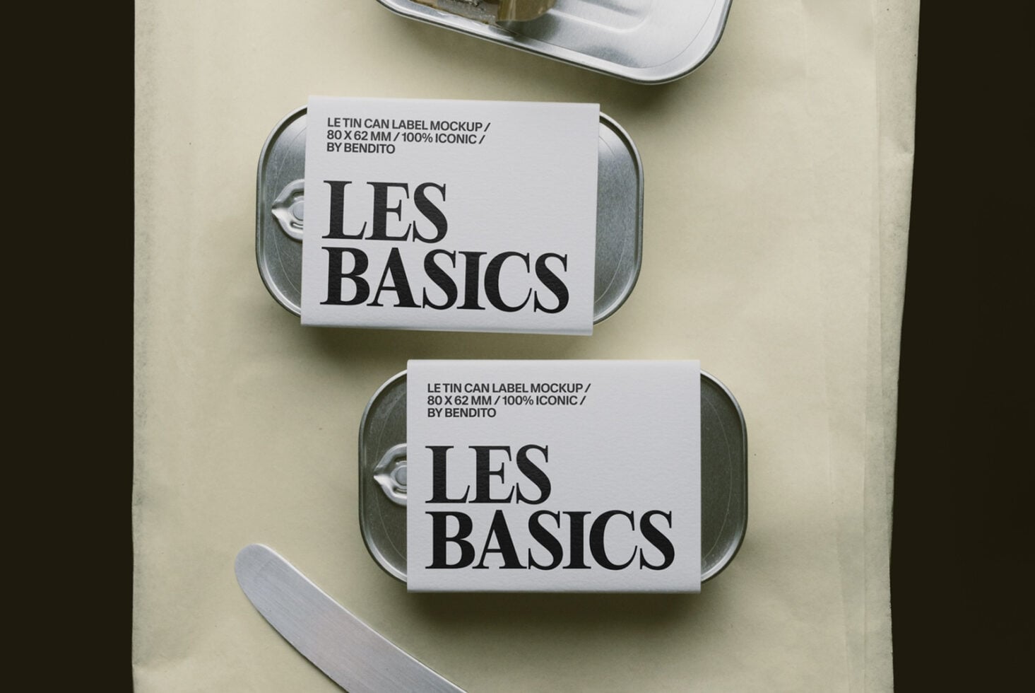 Overhead shot of two metal tins with white labels showing "LES BASICS" branding on cream background