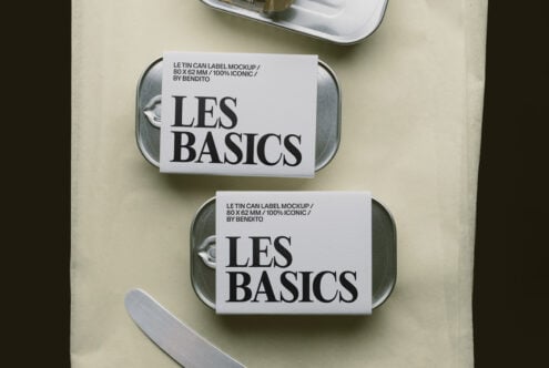 Overhead shot of two metal tins with white labels showing "LES BASICS" branding on cream background