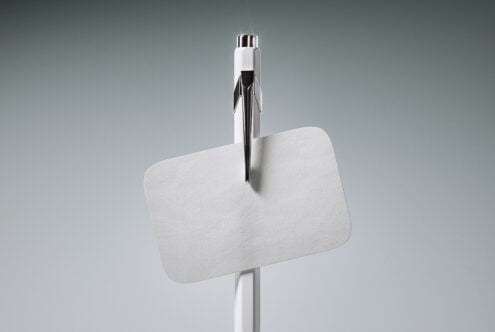 Minimalist pen mockup with blank white card on gray background, chrome details visible