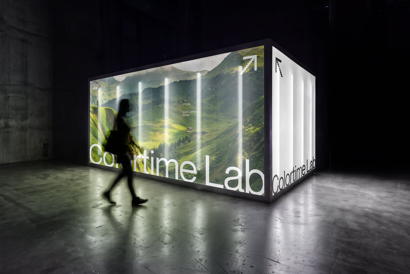 Glowing exhibition booth mockup with landscape imagery, neon lighting, person walking past in dark warehouse space