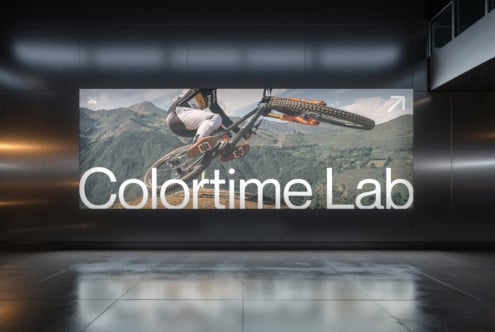 Billboard mockup with dirt bike rider mid-air over mountain landscape, Colortime Lab branding