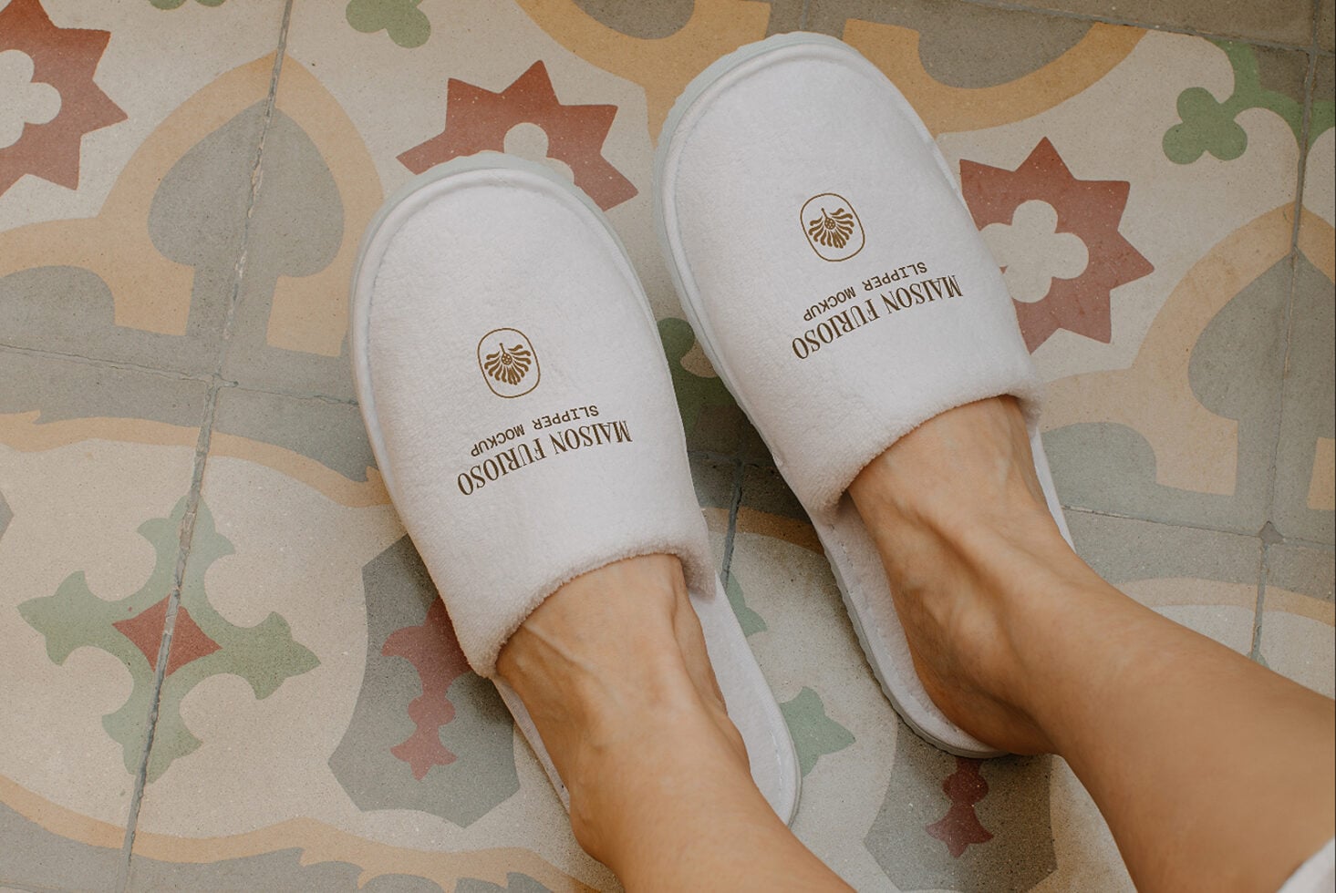 White slippers with shell logo on retro tile floor with geometric shapes