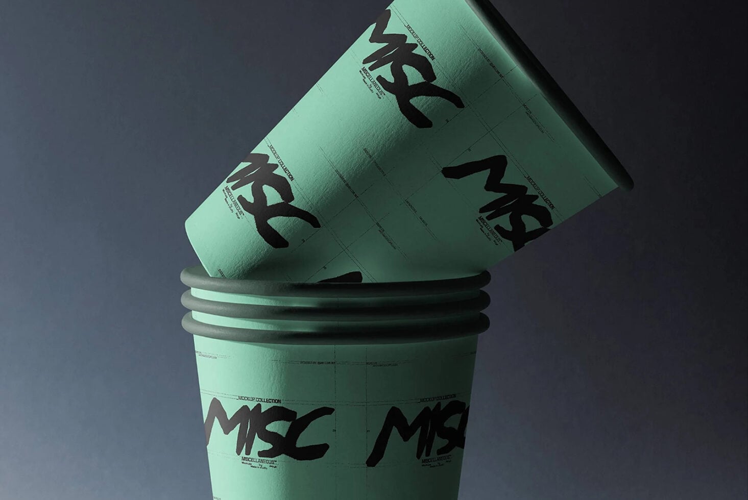 Stacked mint paper cups with bold black logo print, tilted angle on gray background
