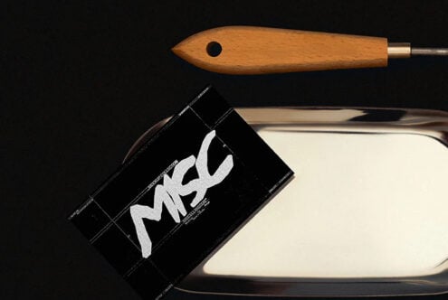 Wooden brush with metal ferrule next to black business card mockup on ceramic dish