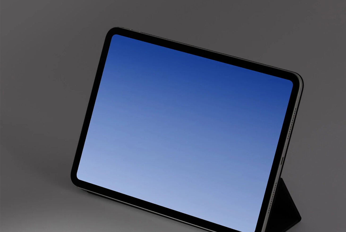 Tablet mockup with blue screen sitting at an angle on gray background