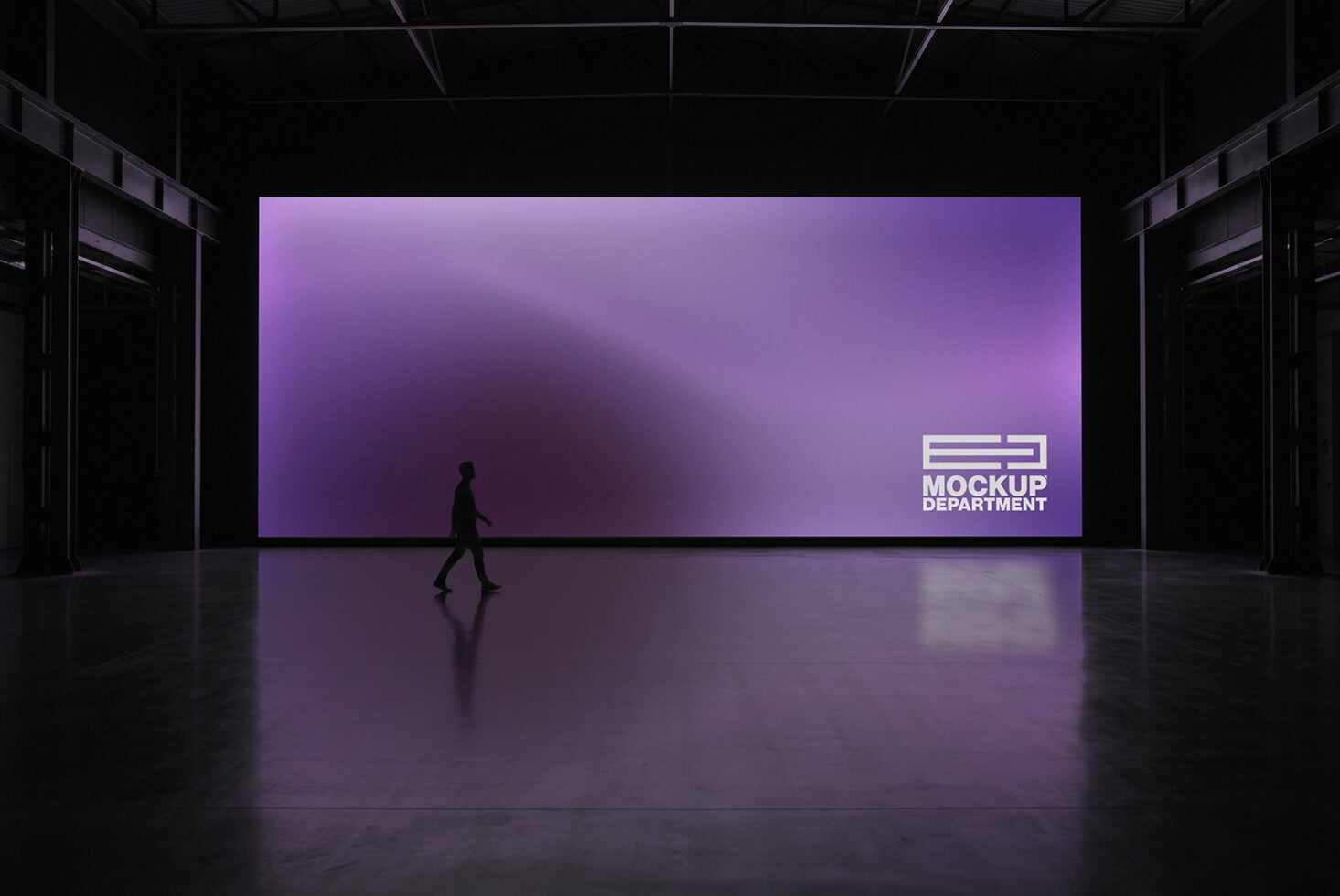 Large purple billboard display in dark warehouse space with silhouetted figure walking past