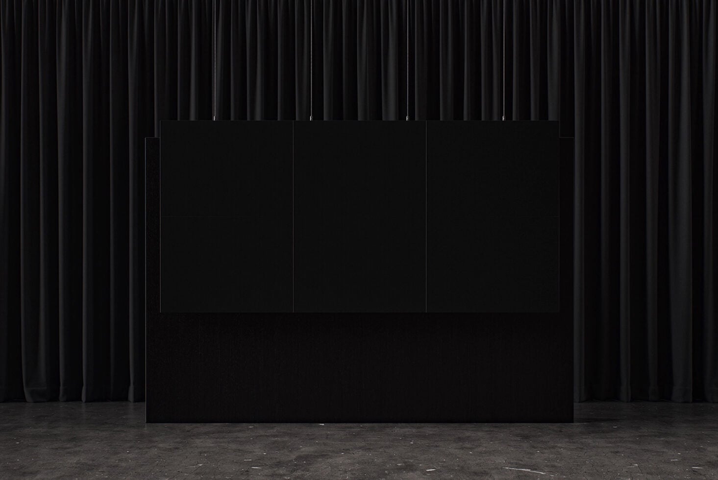 Three blank posters hanging on black curtain backdrop with concrete floor