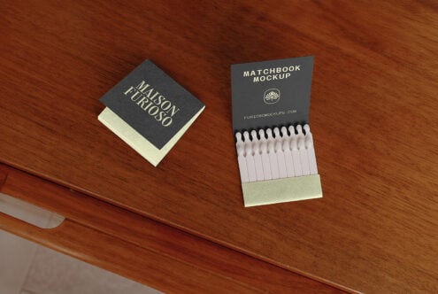 Matchbook mockup with cream matches displayed on wooden table surface next to branded book