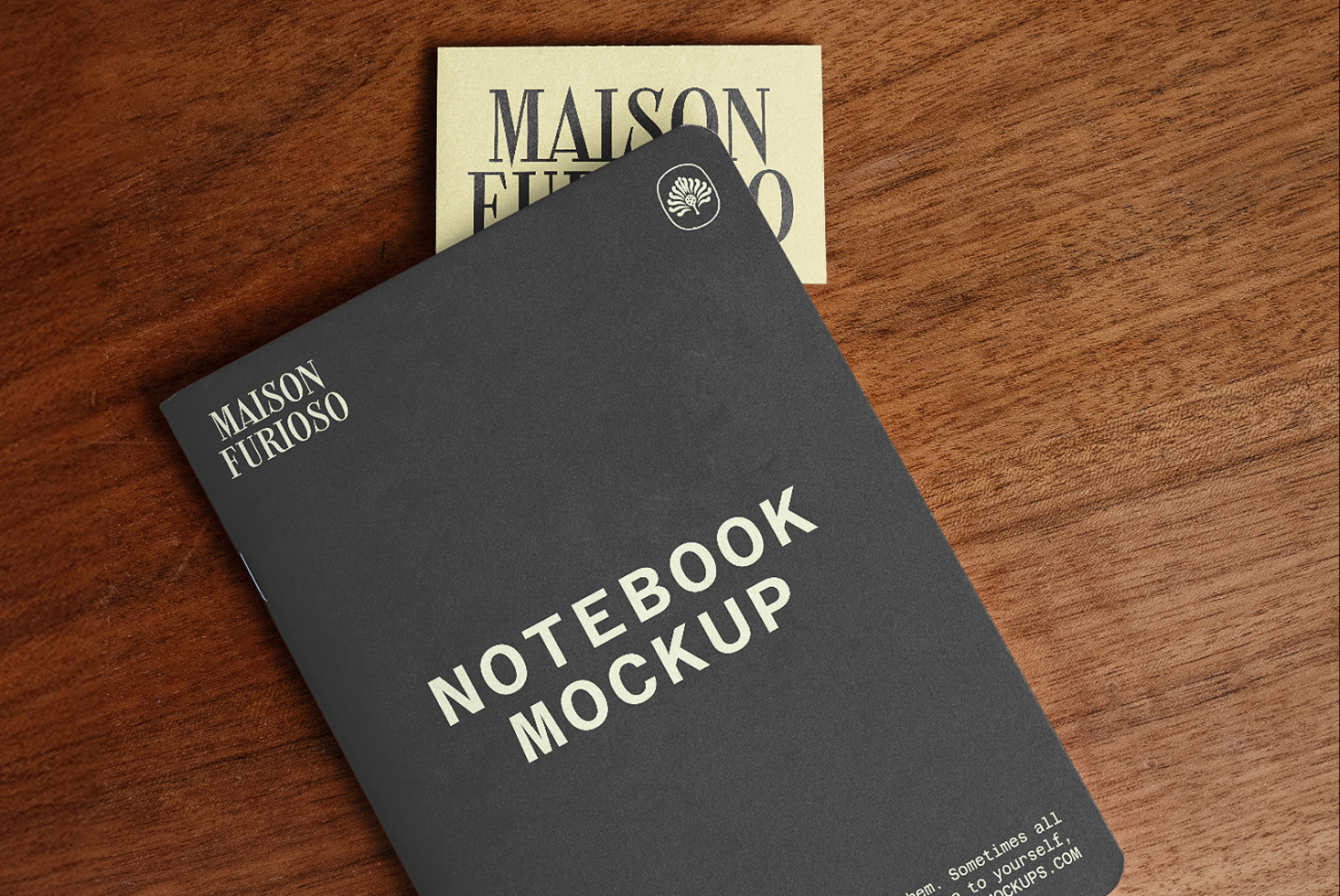 Dark hardcover notebook mockup with cream card showing Maison Furioso branding on wooden surface