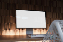 Desktop monitor mockup with keyboard on wooden desk, warm wood slat wall backdrop