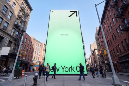 Massive neon green billboard in NYC street with Colortime Lab branding on it