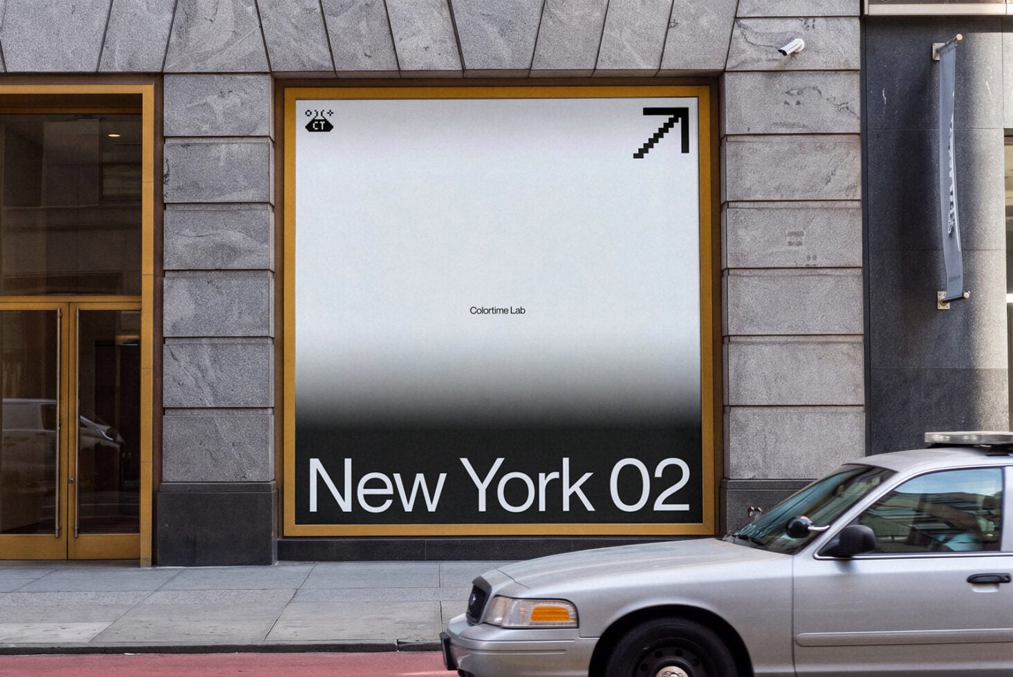 Street storefront mockup showing large framed poster with gradient background, minimal text, gold frame on stone facade