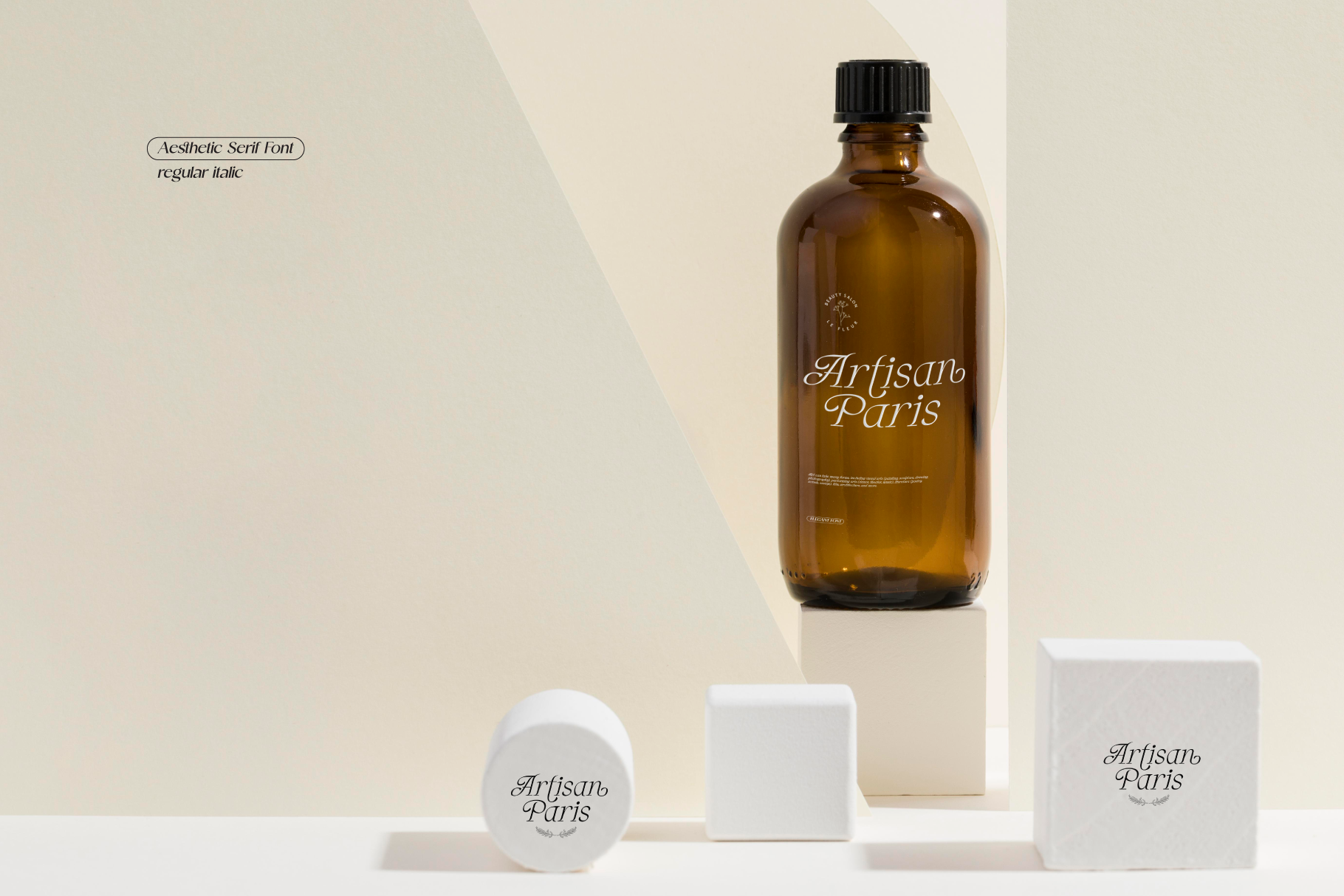 Amber bottle with script branding displayed alongside white cosmetics packaging on neutral podiums