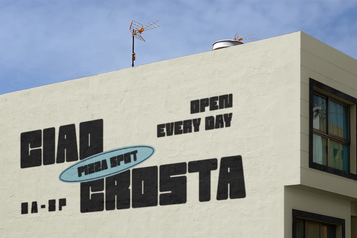 Retro pizza shop storefront with bold black lettering on cream building facade