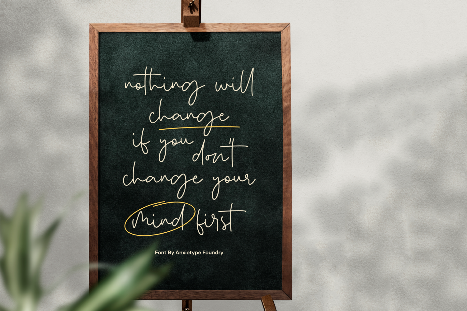 Wooden-framed chalkboard with handwritten motivational quote in script font with yellow accents