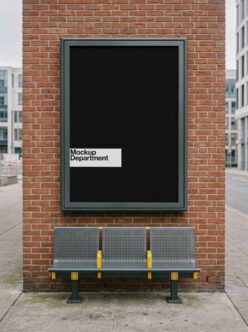Street-facing billboard mockup on red brick with bench below, urban setting