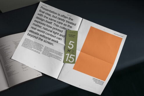 Magazine spread mockup with olive bookmark, orange poster, plus open book on dark surface