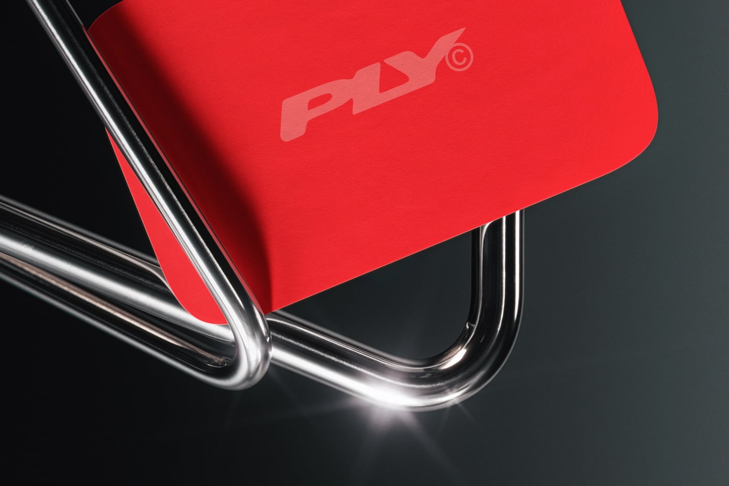 Bright red shopping bag with chrome handles casting sharp shadows on dark background
