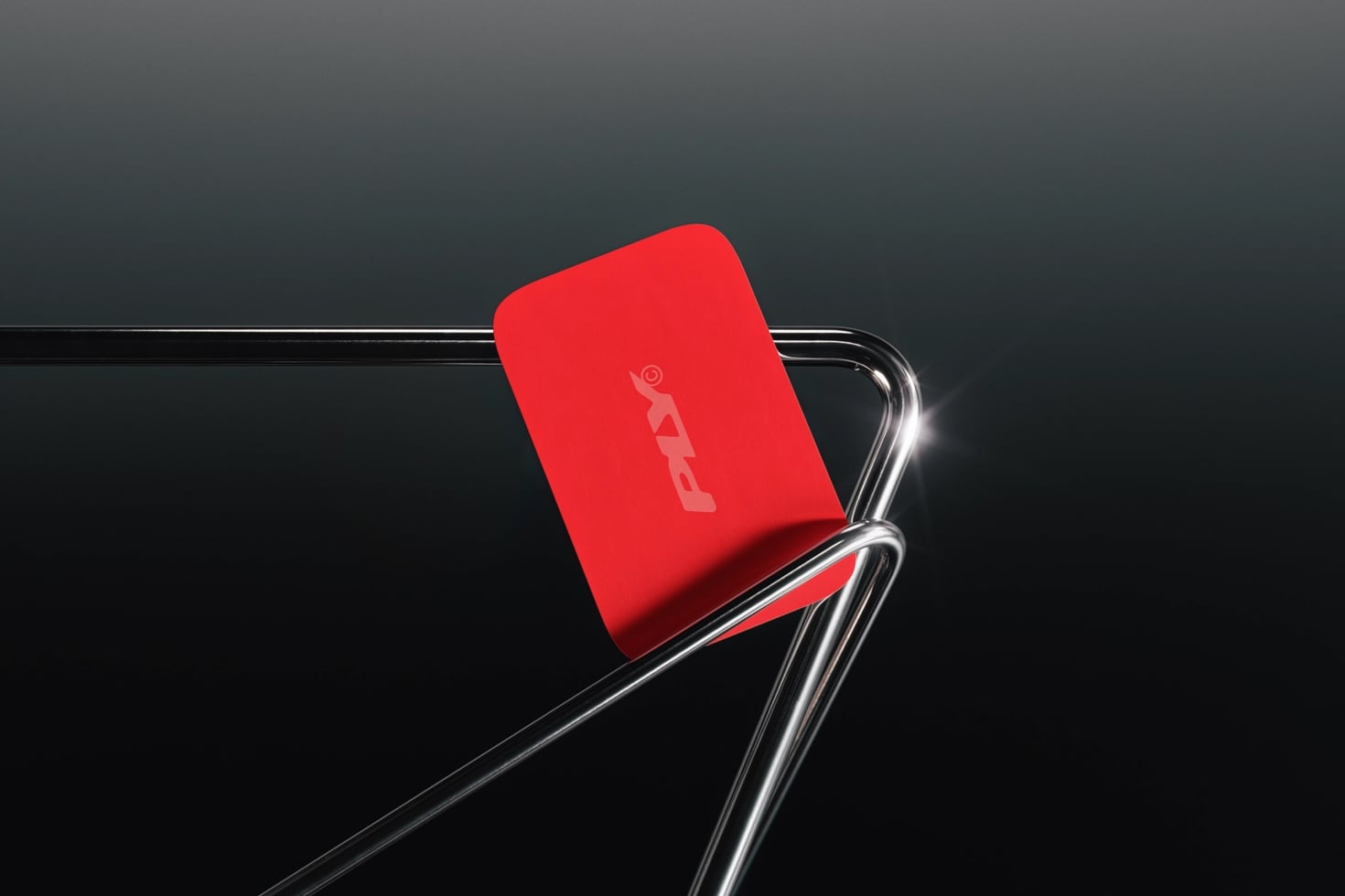 Bright red phone case mockup cradled in sleek chrome stand on dark background