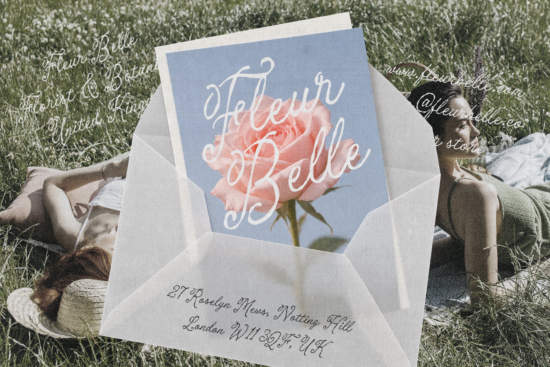 Fleur Belle greeting card mockup with pink rose, blue background, white envelope in grass setting