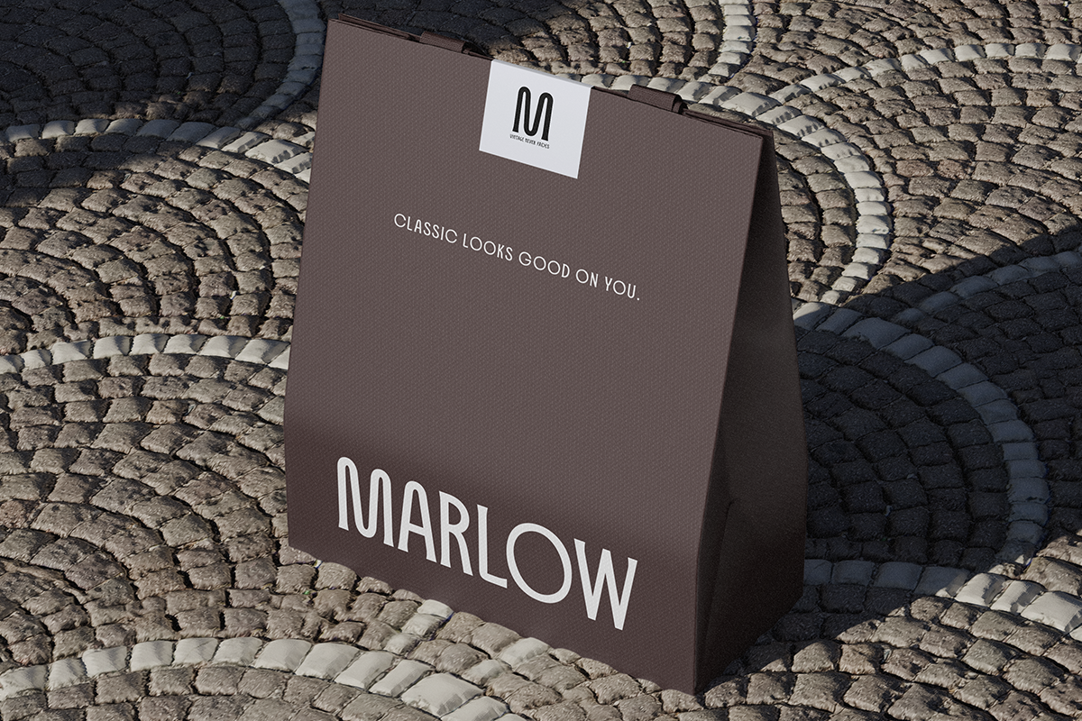 Folded brown shopping bag with white label tag on textured brick background