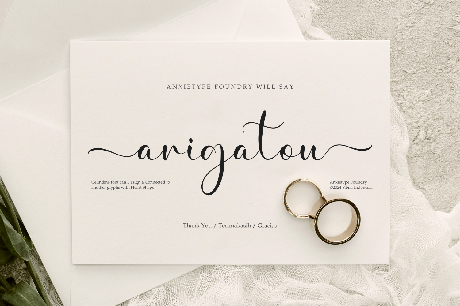 Elegant wedding card with flowing script typography, gold rings, minimal styling on cream background