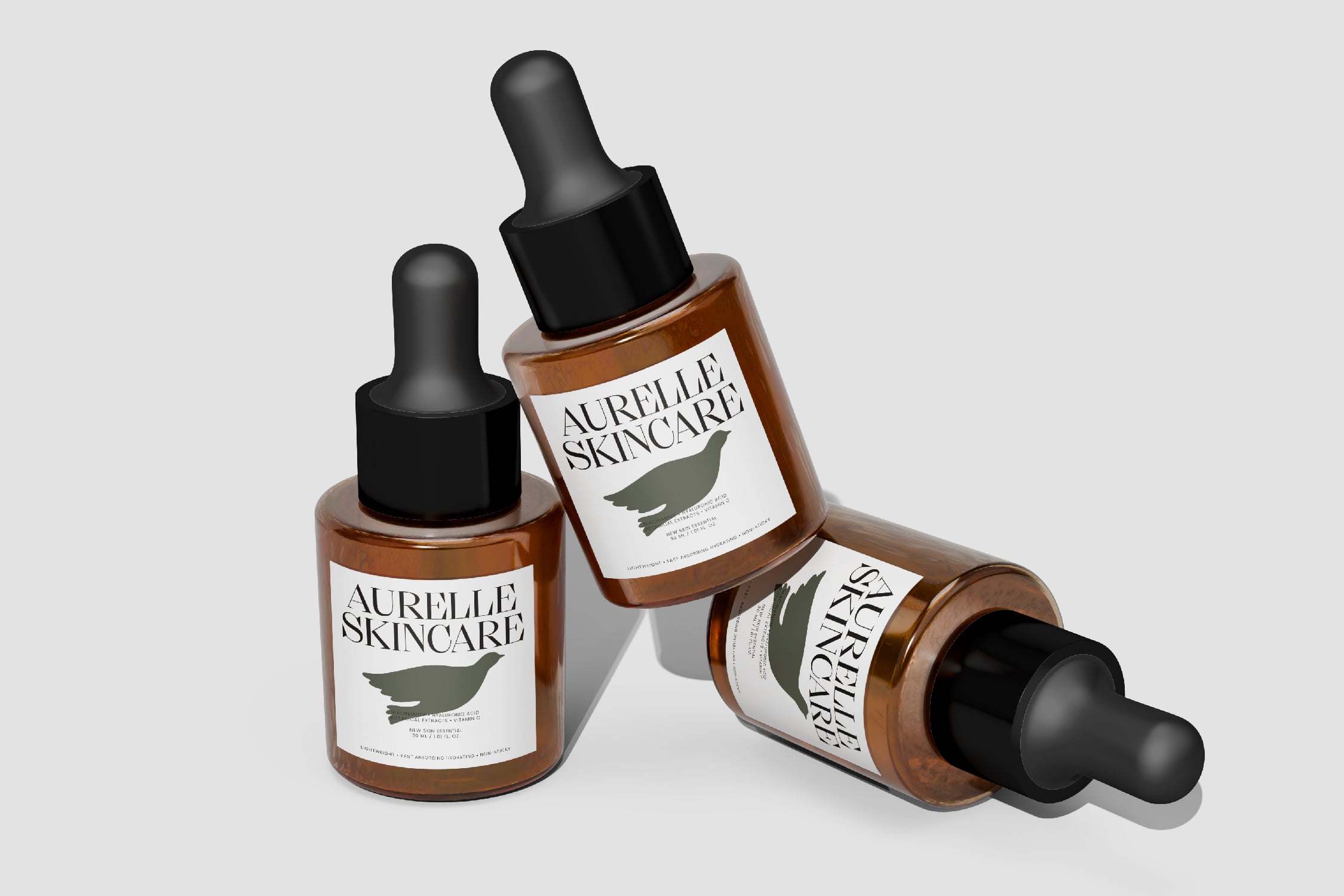 Three amber dropper bottles with black caps labeled Aurelle Skincare, arranged on white background