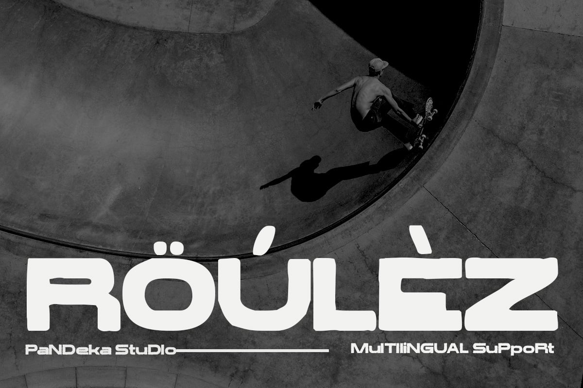 Skateboarder dropping into concrete bowl, black white overhead shot with ROULEZ text overlay