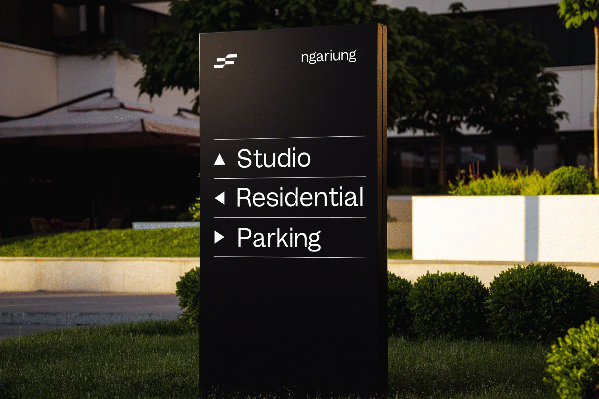 Sleek black wayfinding sign for ngarung development showing studio, residential, parking options