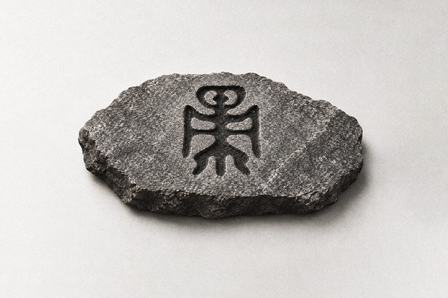 Stone seal mockup with tribal symbol carved into rough granite surface