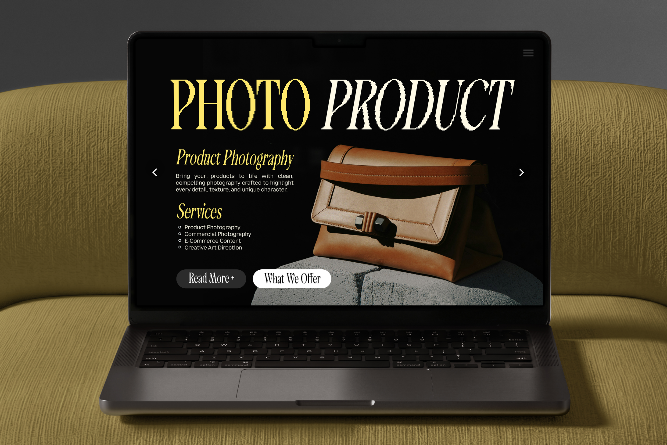 Laptop displaying luxury product photography website with leather bags, gold typography, services list, on textured fabric background