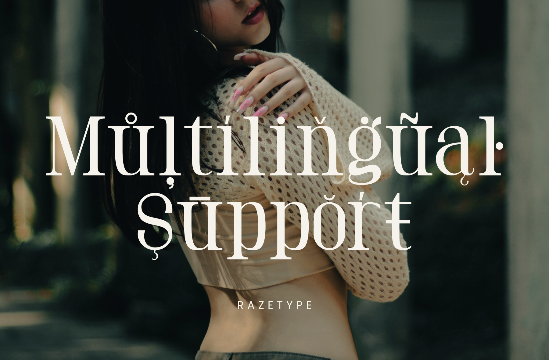 Woman in cream cardigan with pink nails holding sweater sleeve, moody urban backdrop with serif text overlay