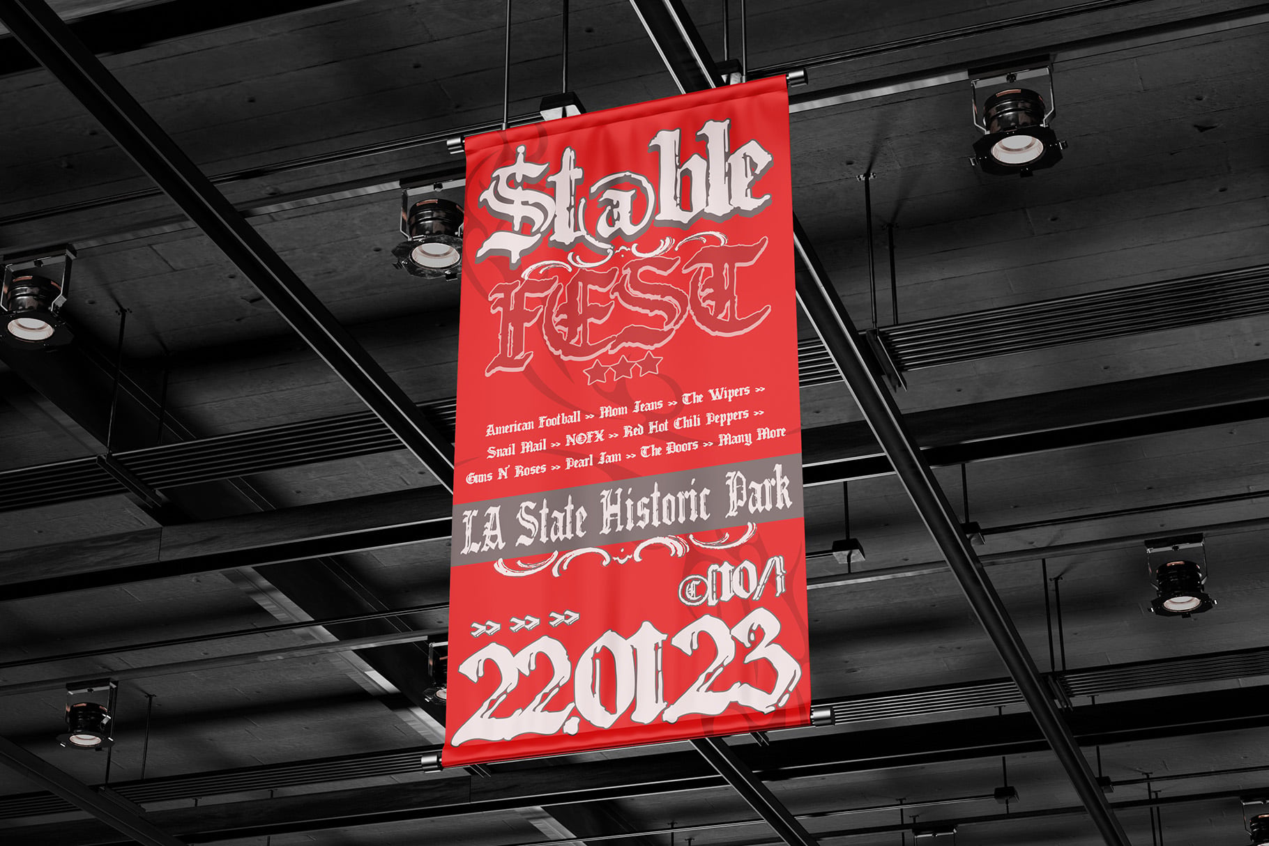 Bright red banner hanging from industrial ceiling with white gothic lettering for Stable Feast event poster
