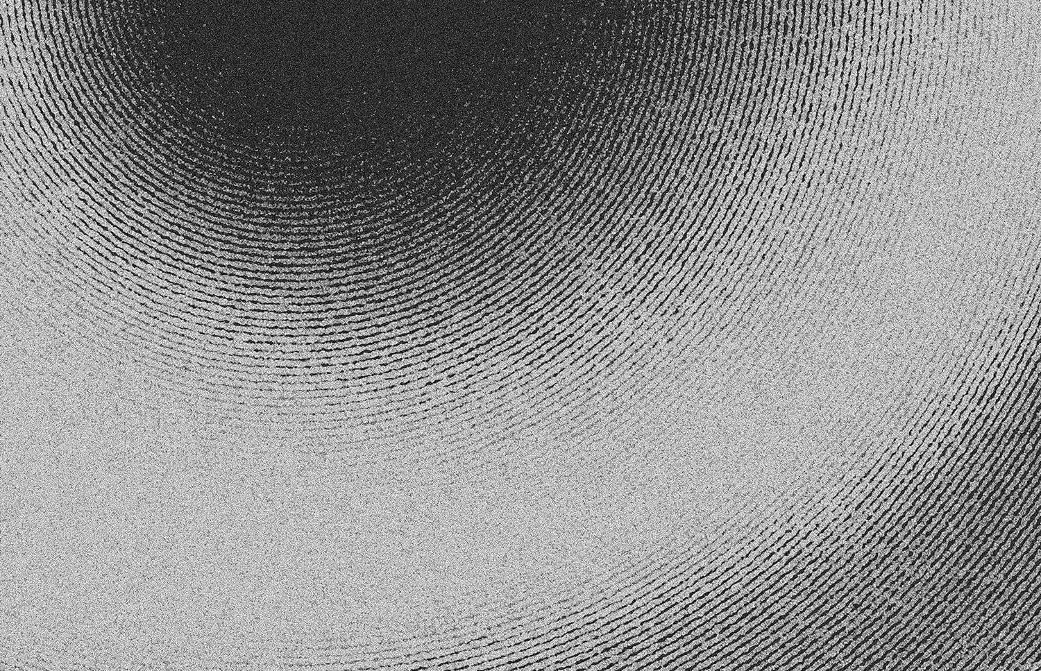 Grayscale abstract texture with curved linear patterns flowing from dark to light