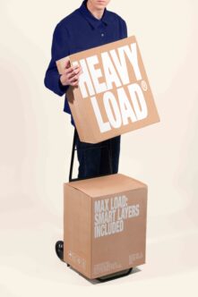 Man in navy shirt holding cardboard box mockup with heavy load branding
