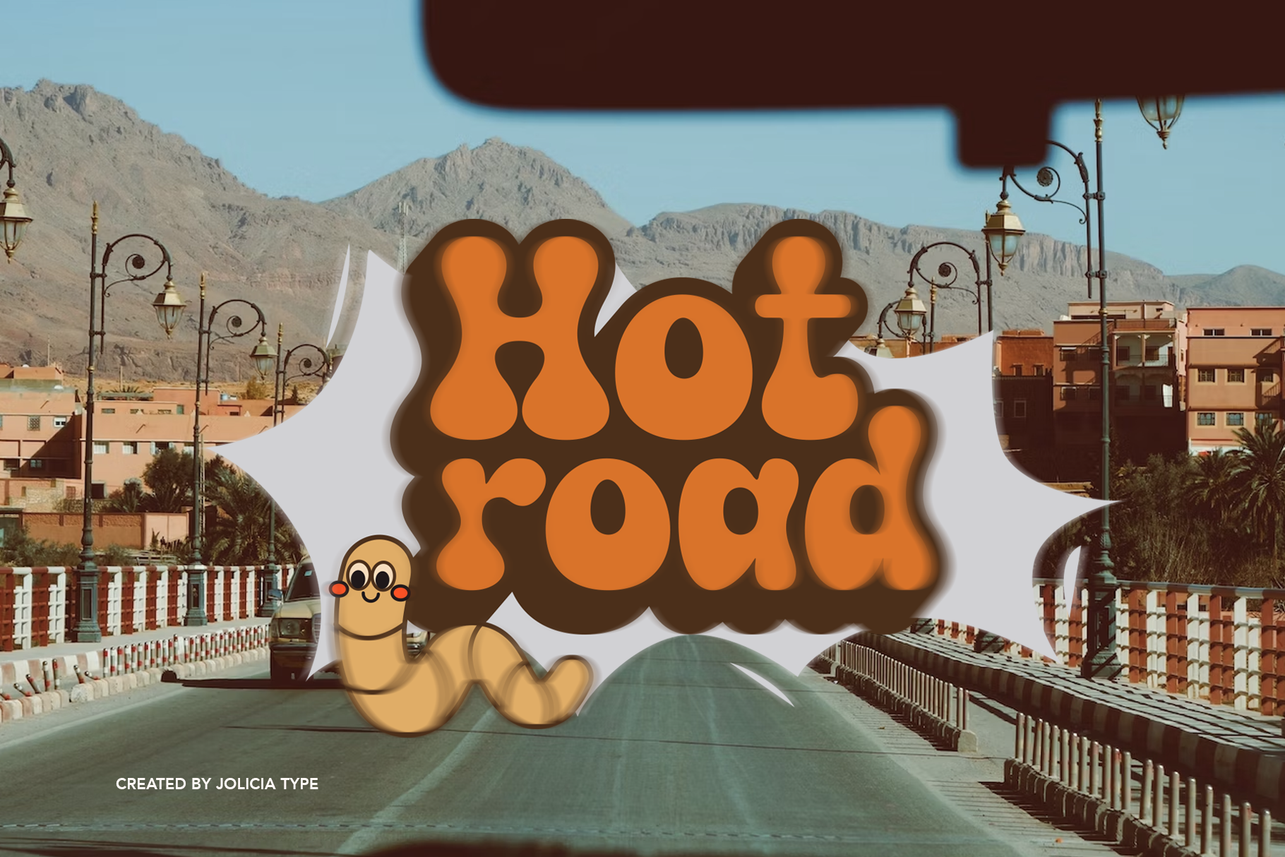 Groovy retro worm character with "Hot Road" text overlaid on desert highway landscape