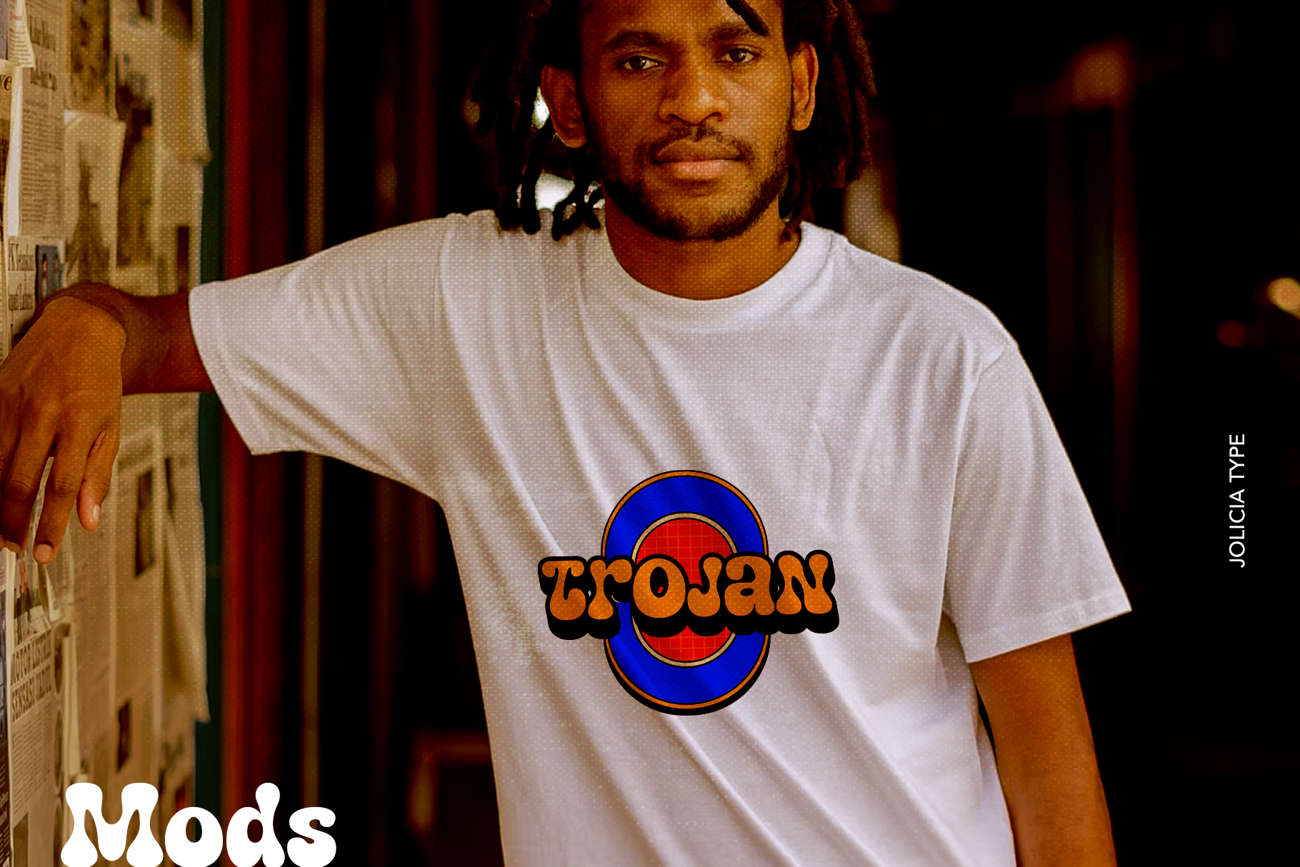 Guy wearing white tee with retro Trojan Records logo mockup in warm studio lighting