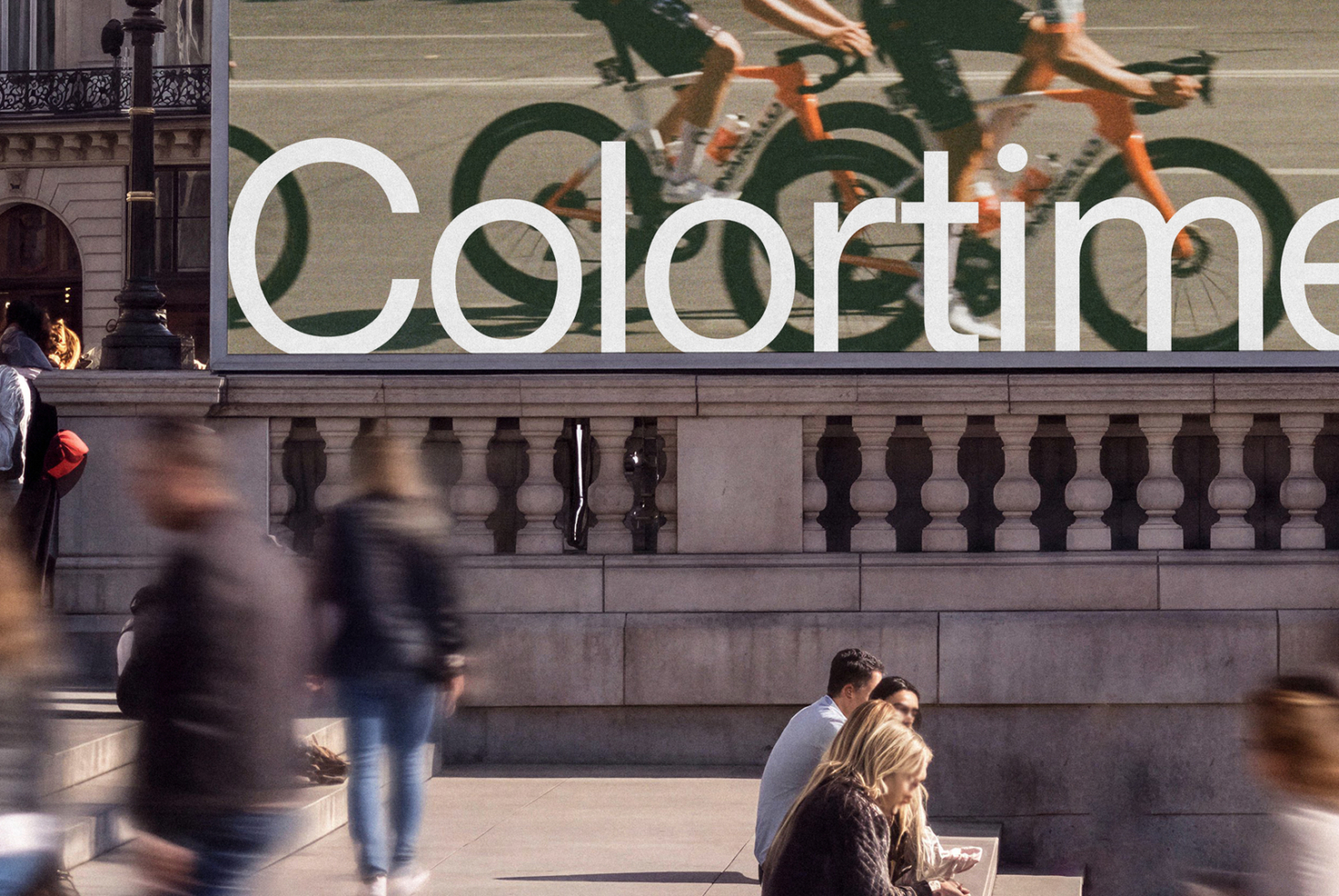 Storefront sign reading "Colortime" in white sans serif on urban building facade with bikes in background