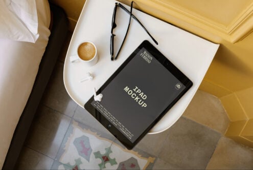 iPad mockup flat lay with coffee, glasses, earbuds on white desk