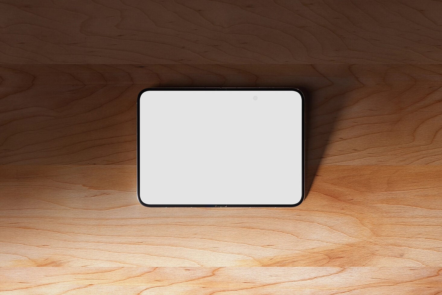 Smartphone with black frame on warm wooden table with soft shadow