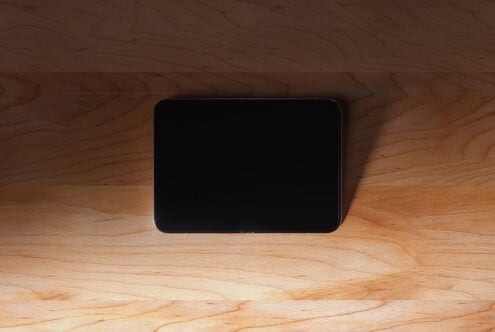 Tablet mockup on wood surface with natural light casting shadows