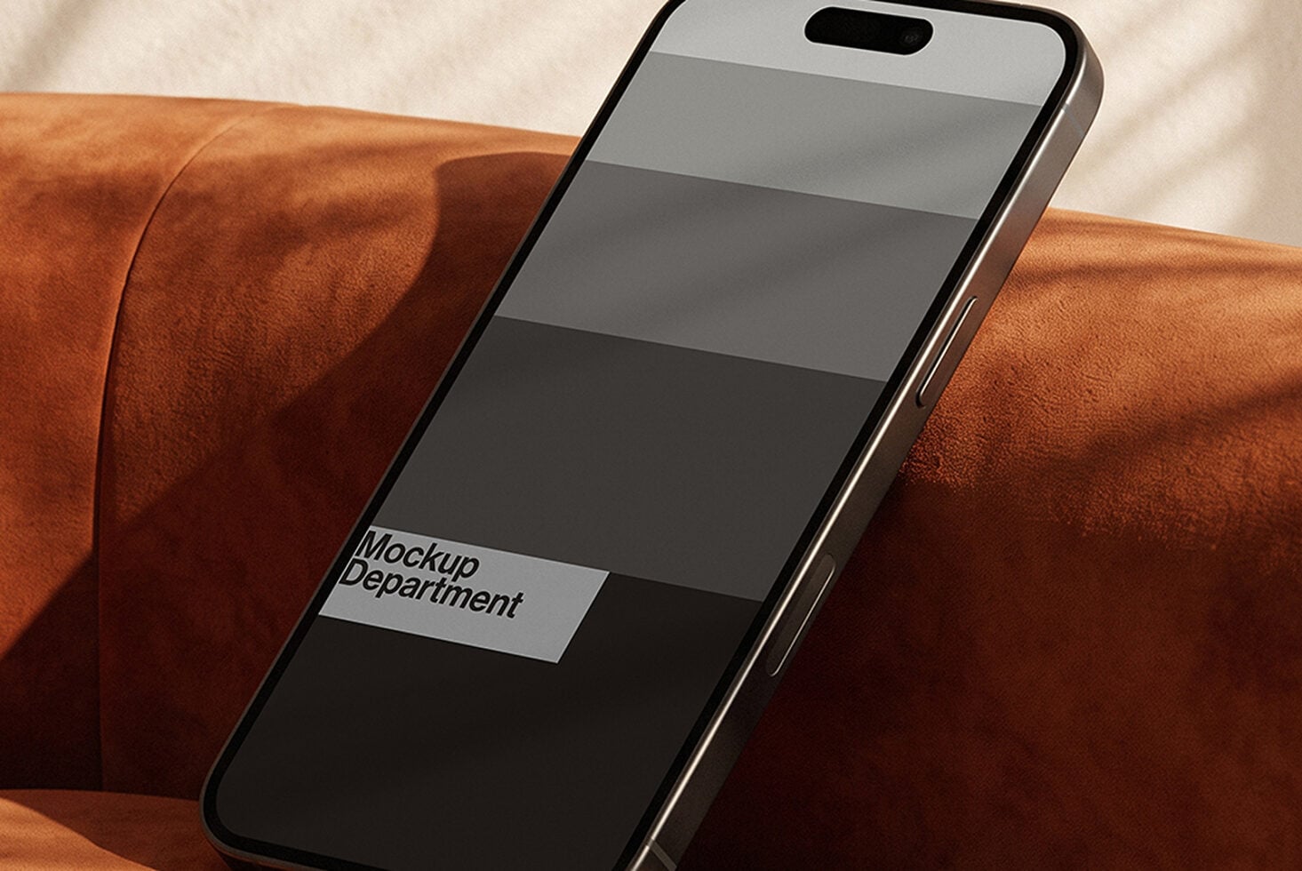 iPhone mockup resting on rust-colored suede fabric with app screen display