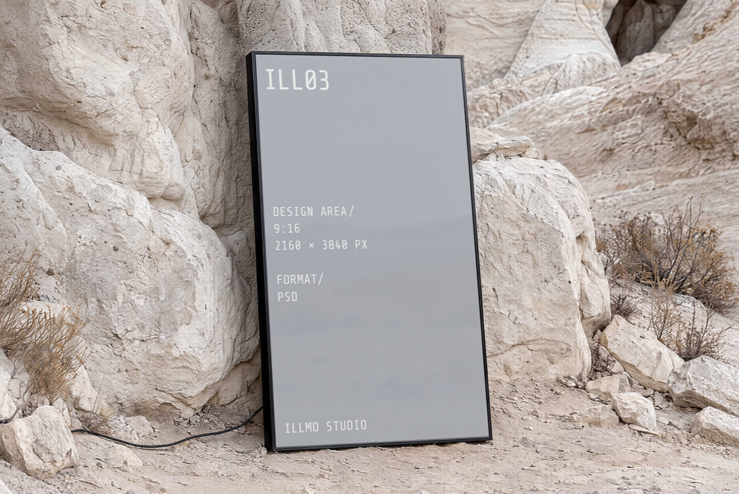 Vertical phone mockup with gray screen leaning against textured stone rocks in desert landscape setting