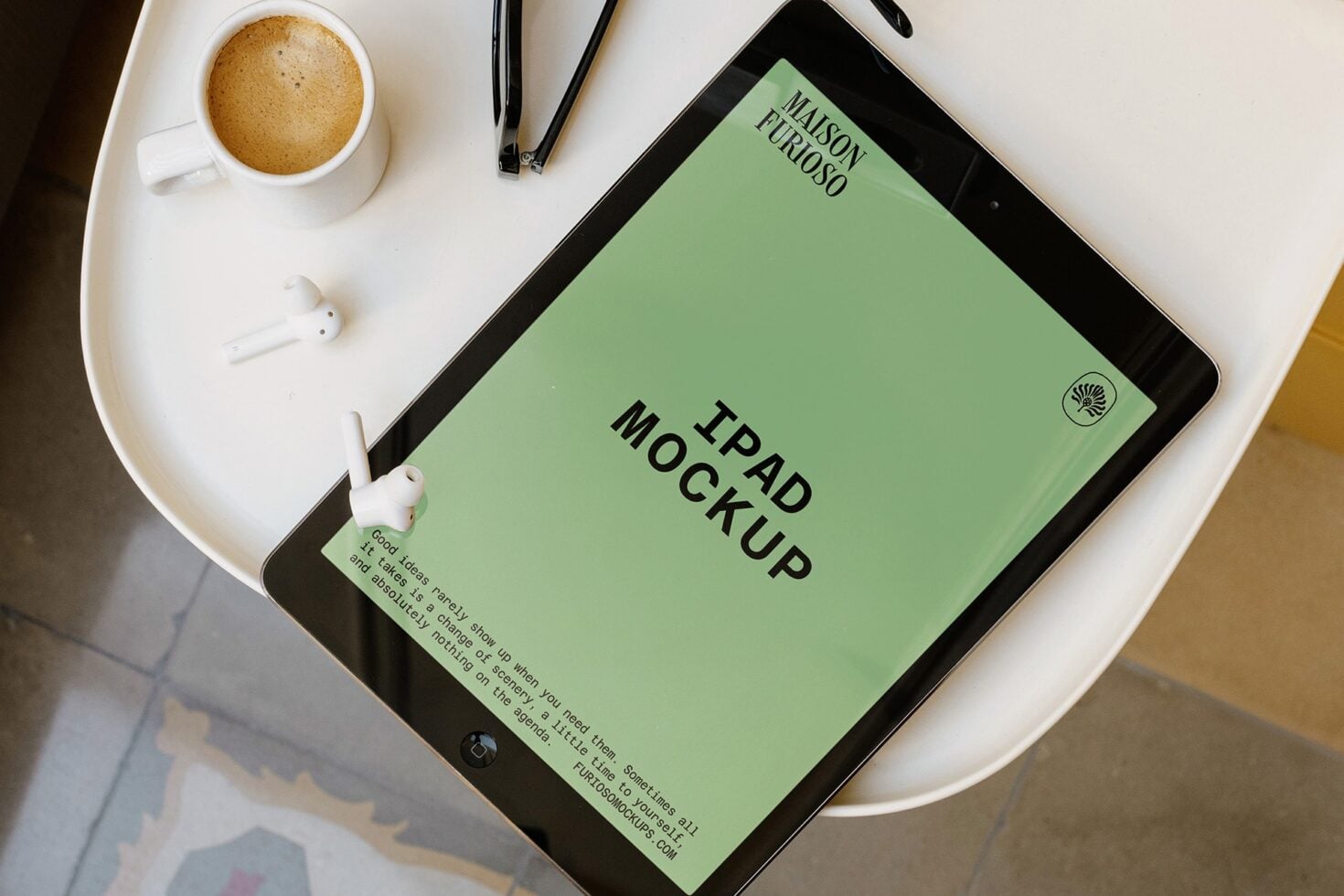 iPad mockup with sage green screen displaying "iPad Mockup" text, styled desk setup with coffee cup, earbuds, pens