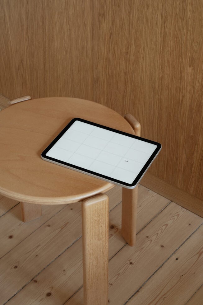 Tablet mockup on wooden round table in minimal interior with wood paneling