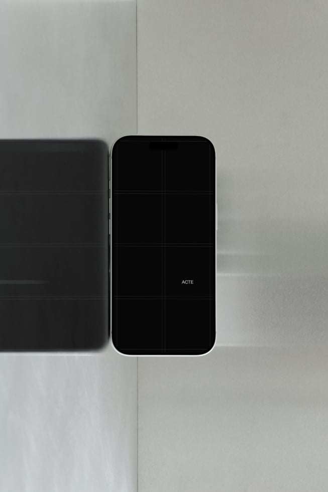 Smartphone mockup with blank screen next to tablet on minimal gray surface with soft shadows
